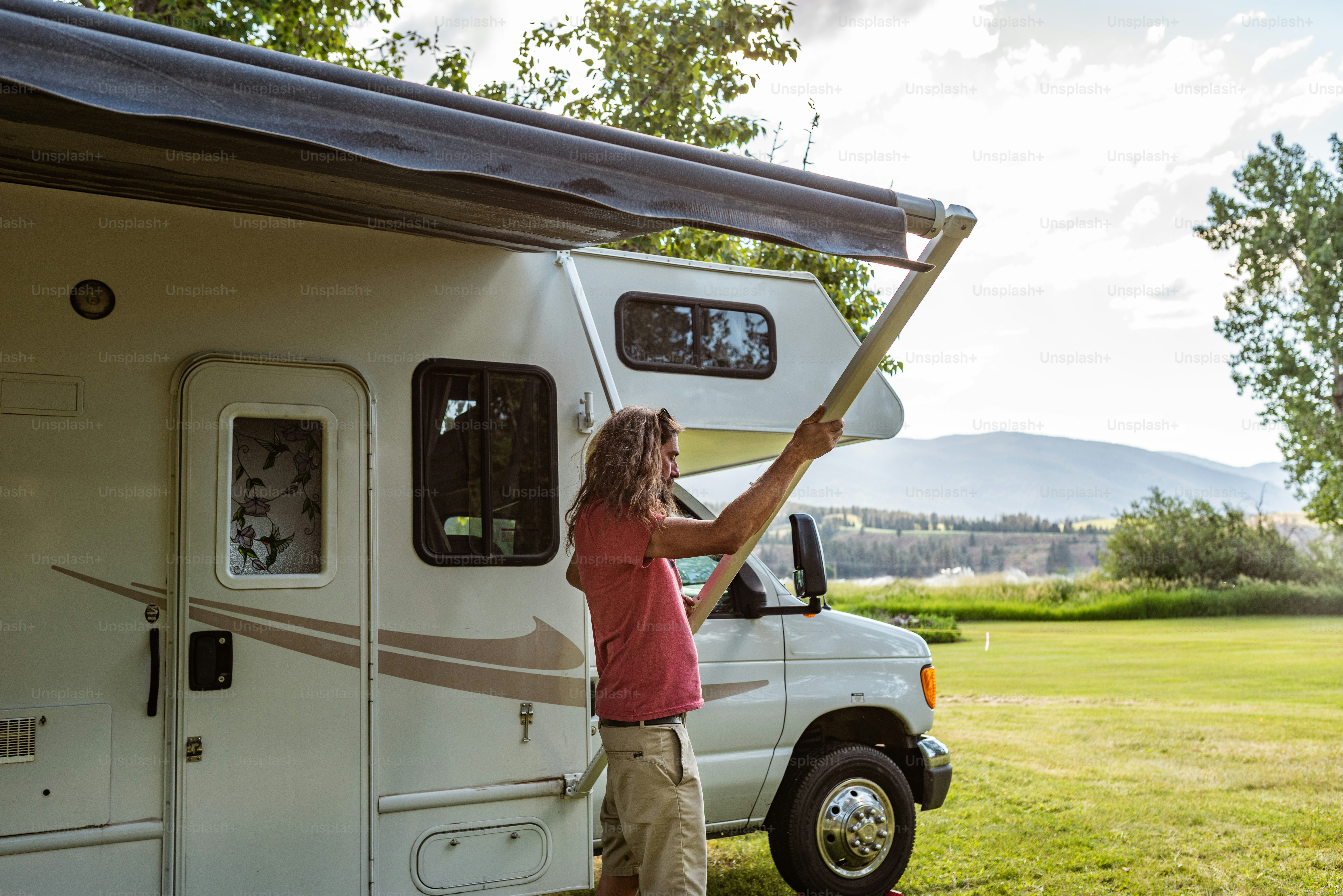Un uomo in piedi accanto a un camion bianco in un campo