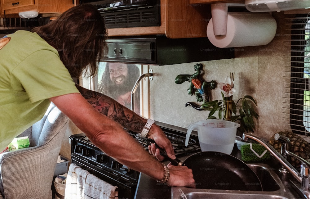 Un uomo con una camicia verde sta cucinando in una cucina