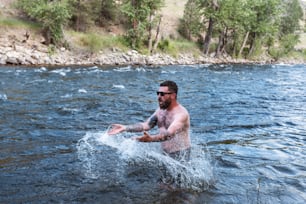 男が川に水しぶきをかける