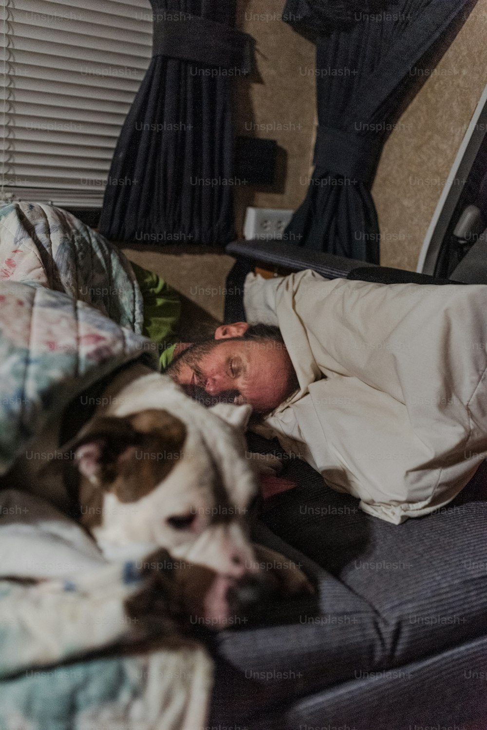 a man laying in bed next to a dog