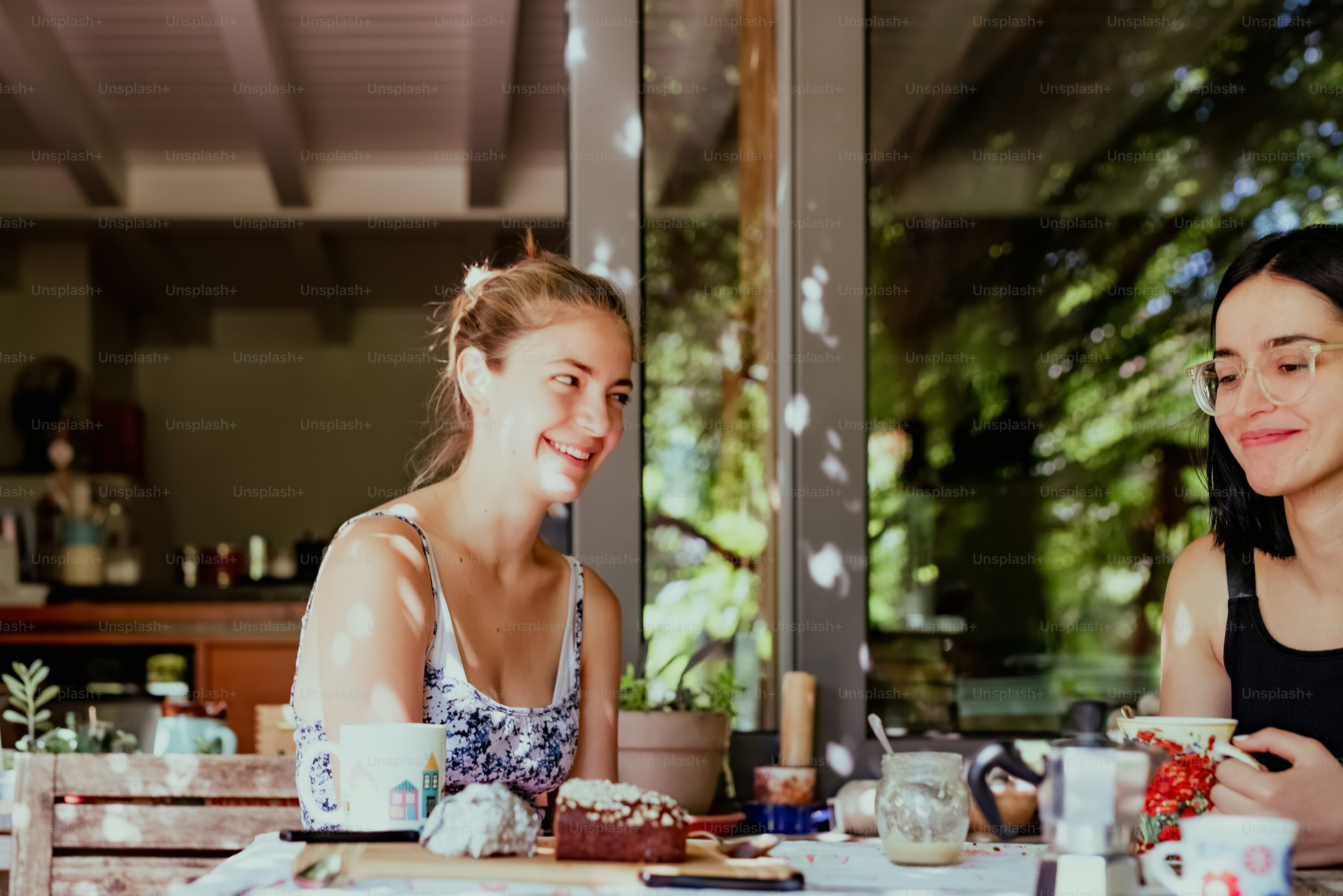 two women sitting at a table having a conversation