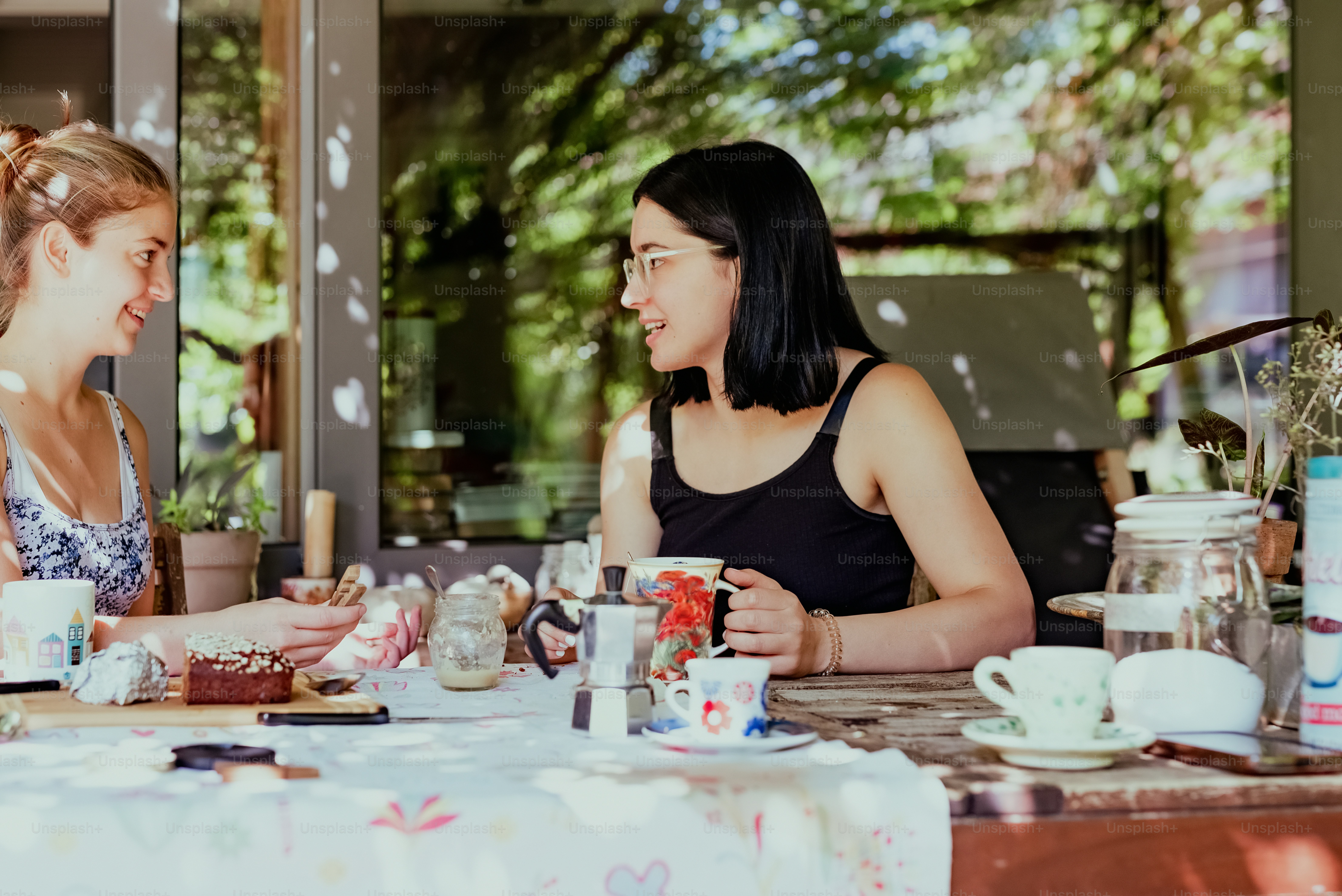 two women sitting at a table having a conversation