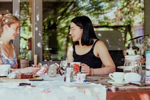two women sitting at a table having a conversation