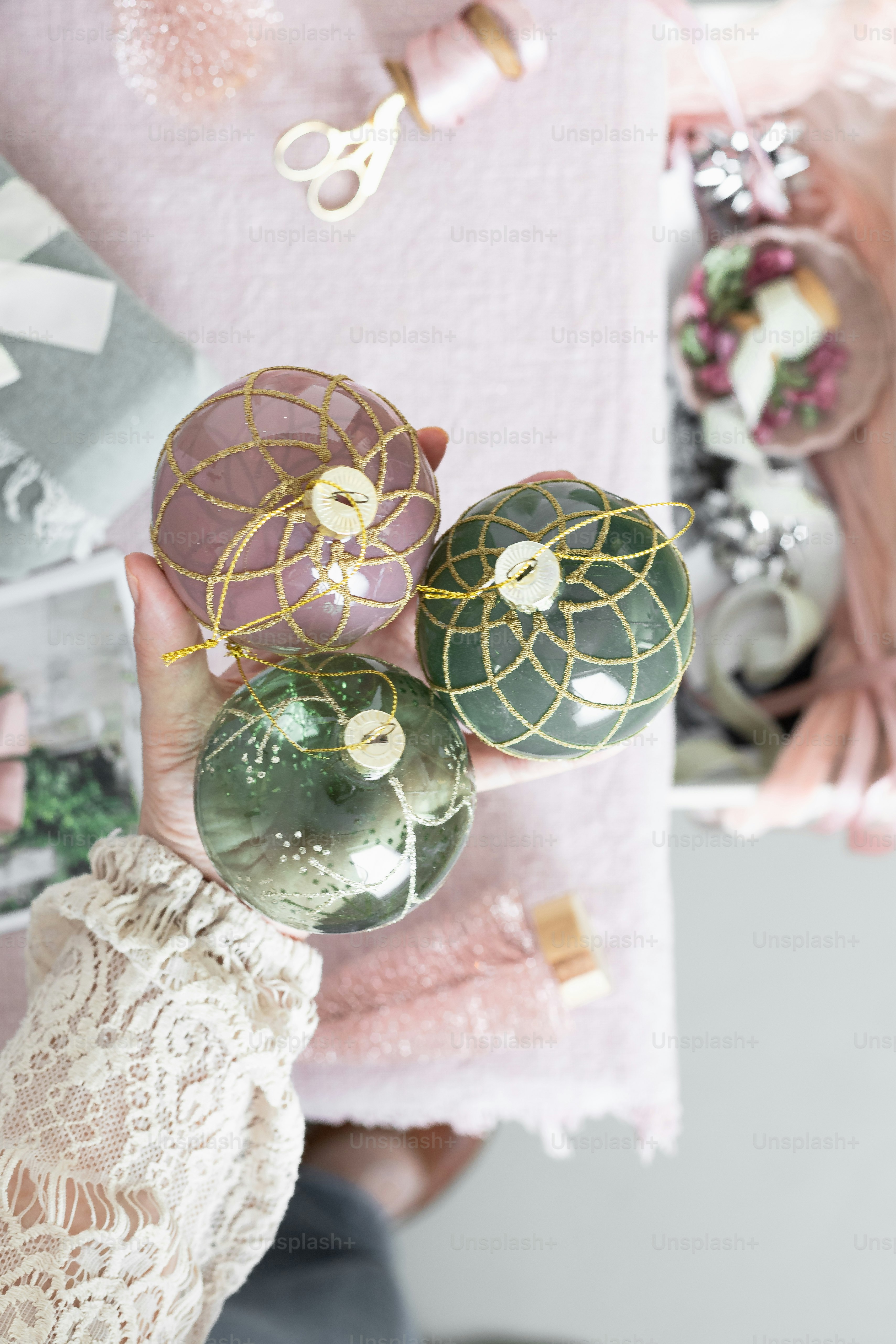a person holding three ornaments in their hands