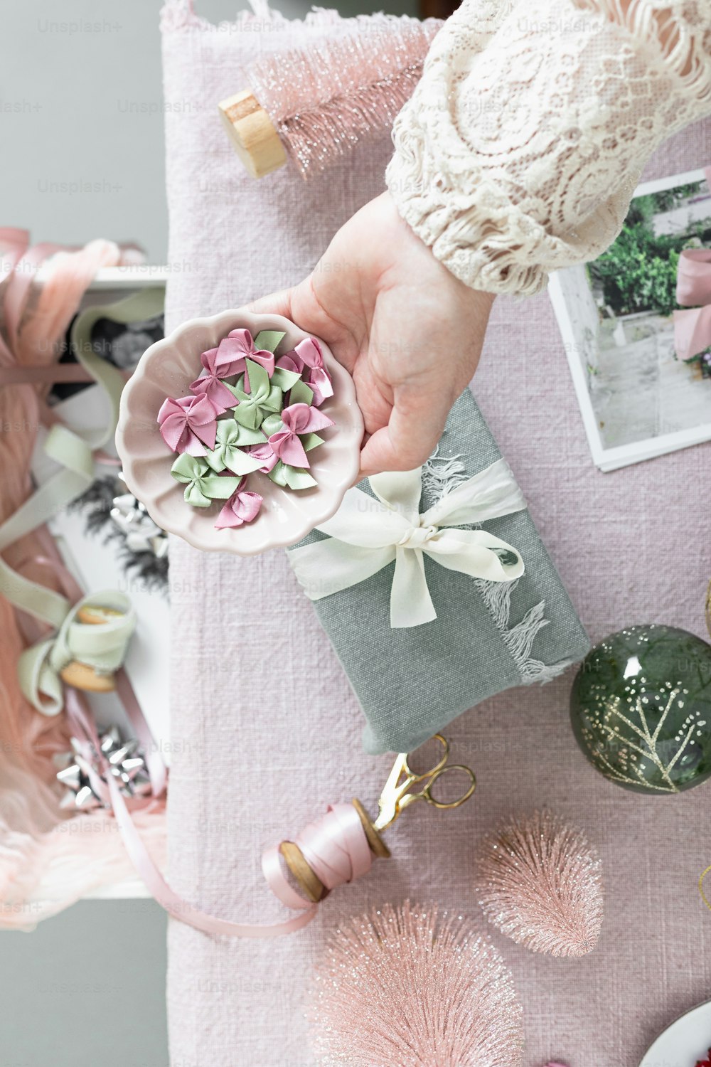 a person holding a small flower on top of a table