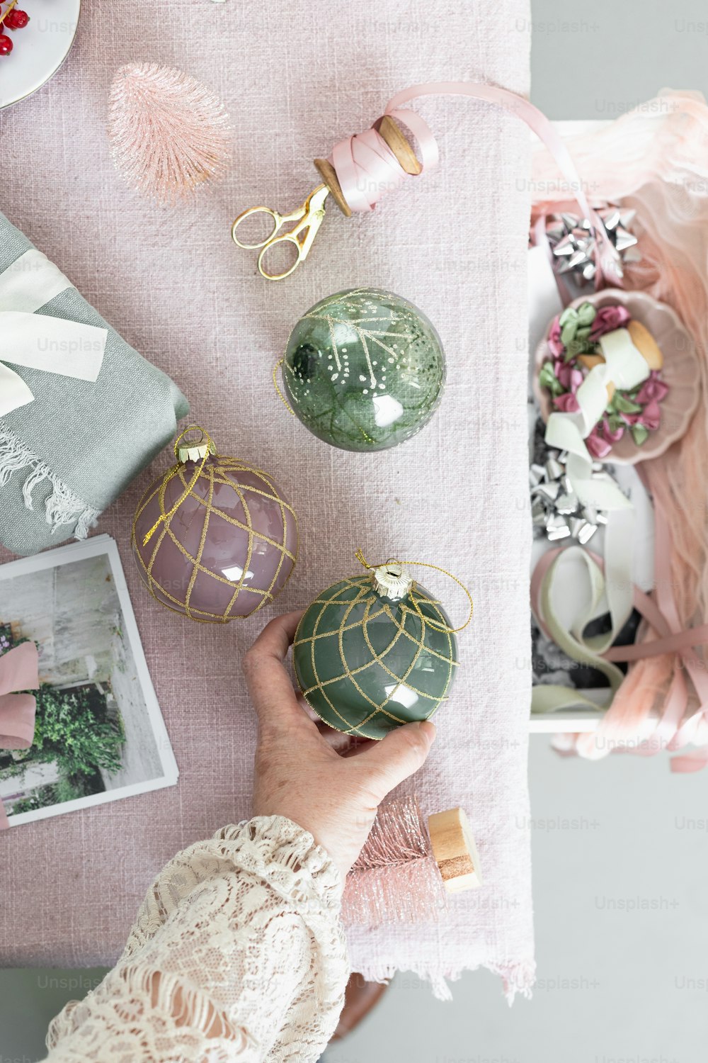 a person holding a green ornament on top of a table