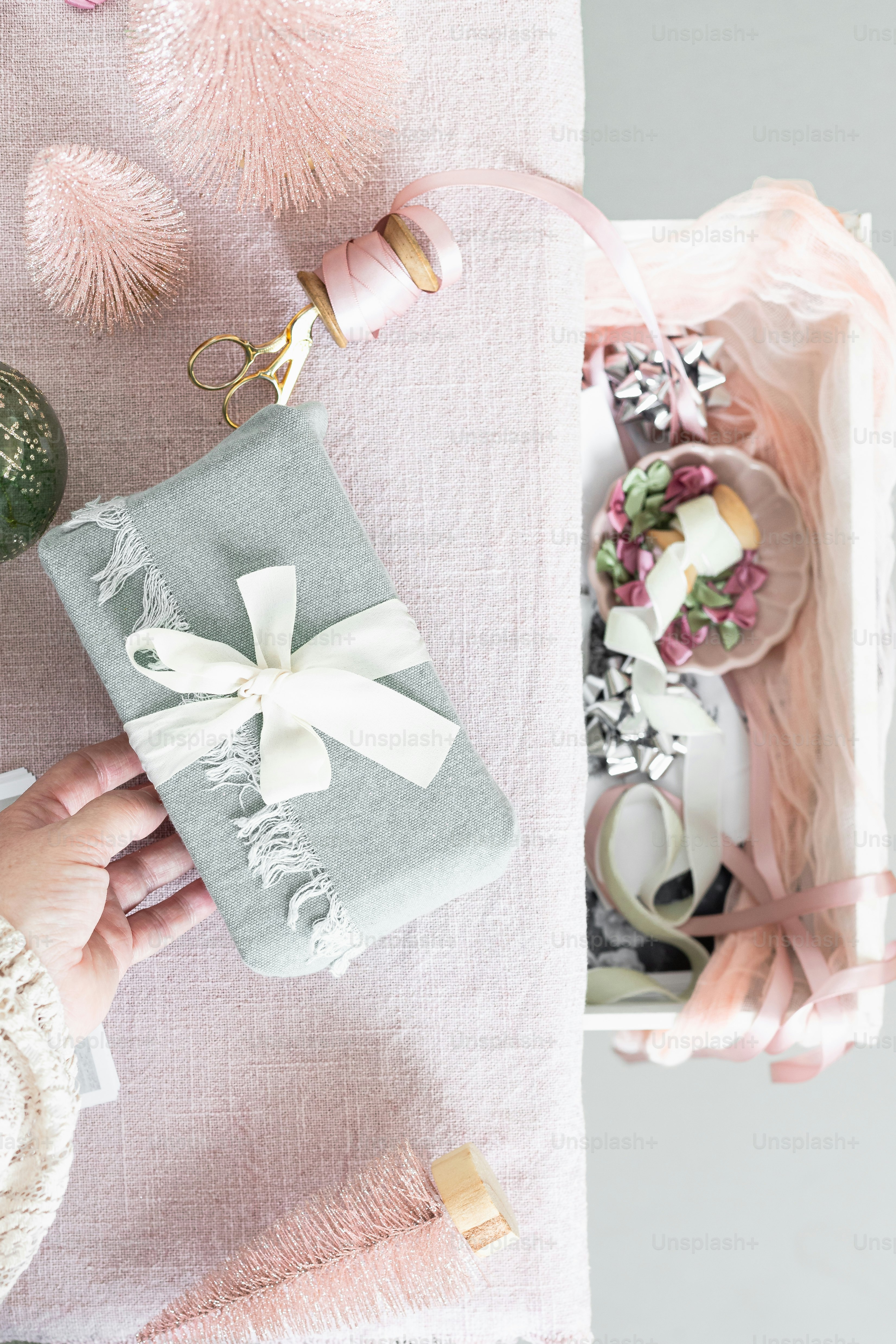 a person holding a wrapped present on top of a table