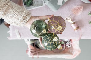 a person is holding some ornaments on a table