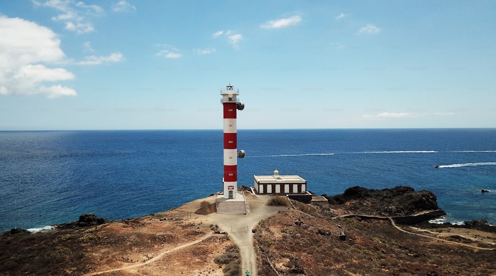 aerial view of beautiful landscape with lighthouse old and new on the cliff of Tenerife in front to the Atlantic ocean. Lonely cyclist arriving