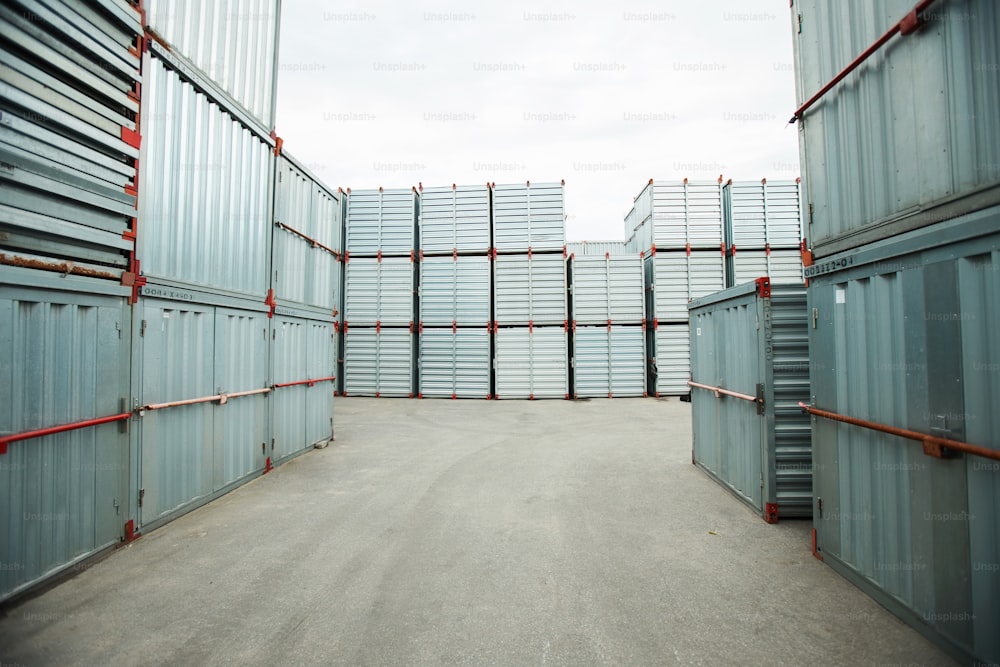 Abundância de contêineres de carga de metal selados empilhados ao ar livre, armazenamento de transporte