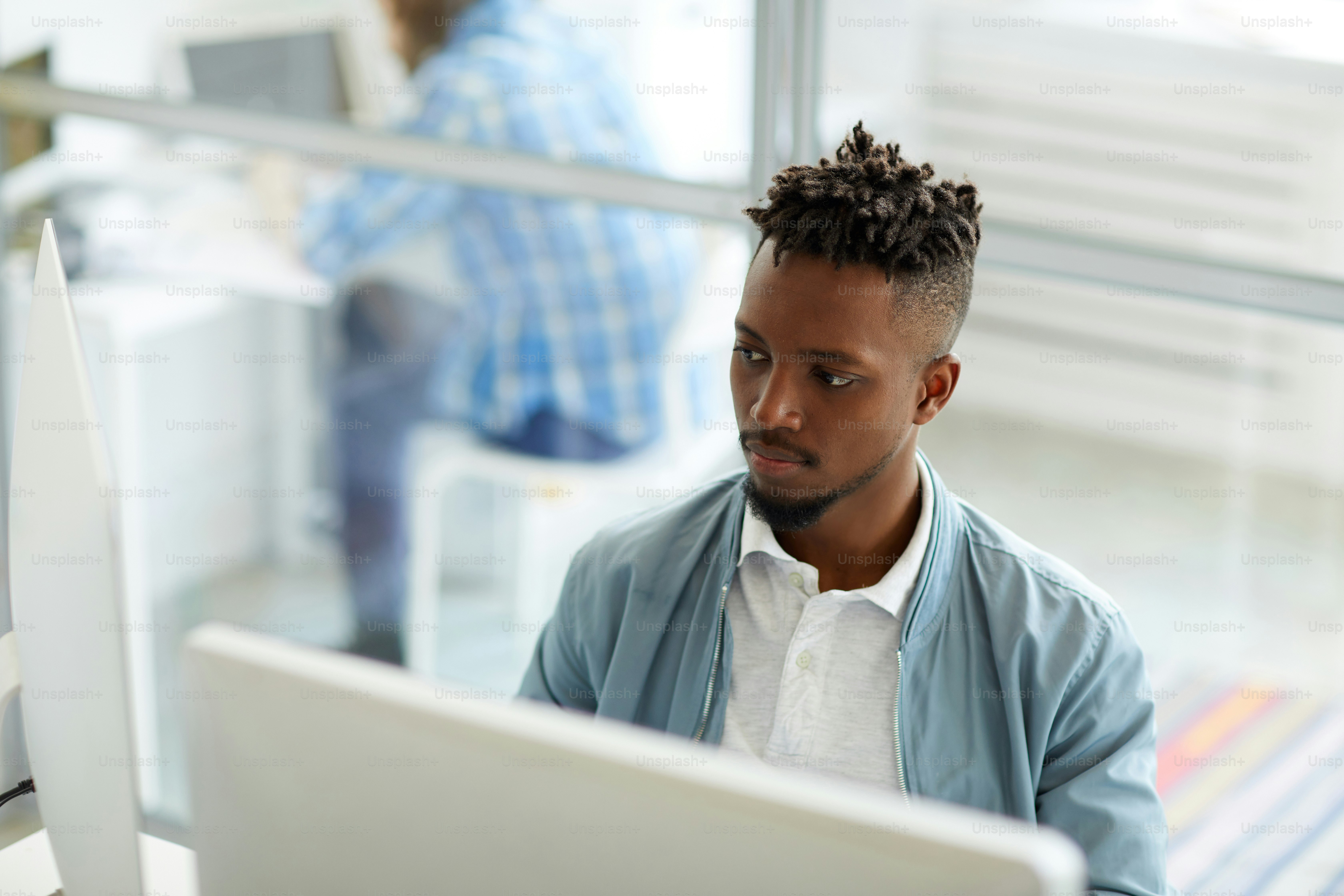 Jeune homme d'affaires afro-américain assis devant deux écrans d'ordinateur  et analysant des données photo – Image de Bureau sur Unsplash, image size:3000x2000