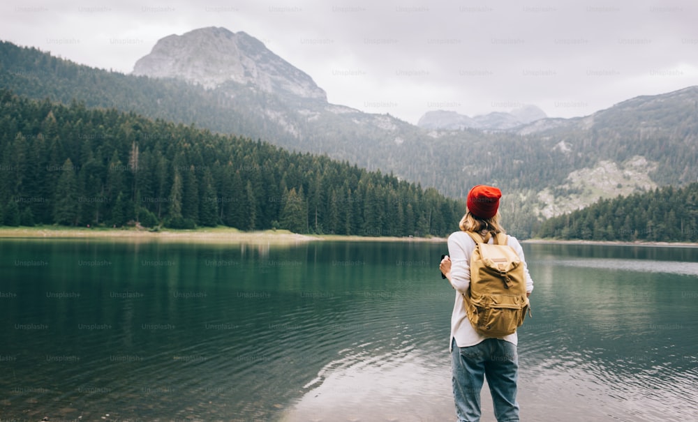 Randonneuse solitaire se reposant au bord d’un lac de montagne.
