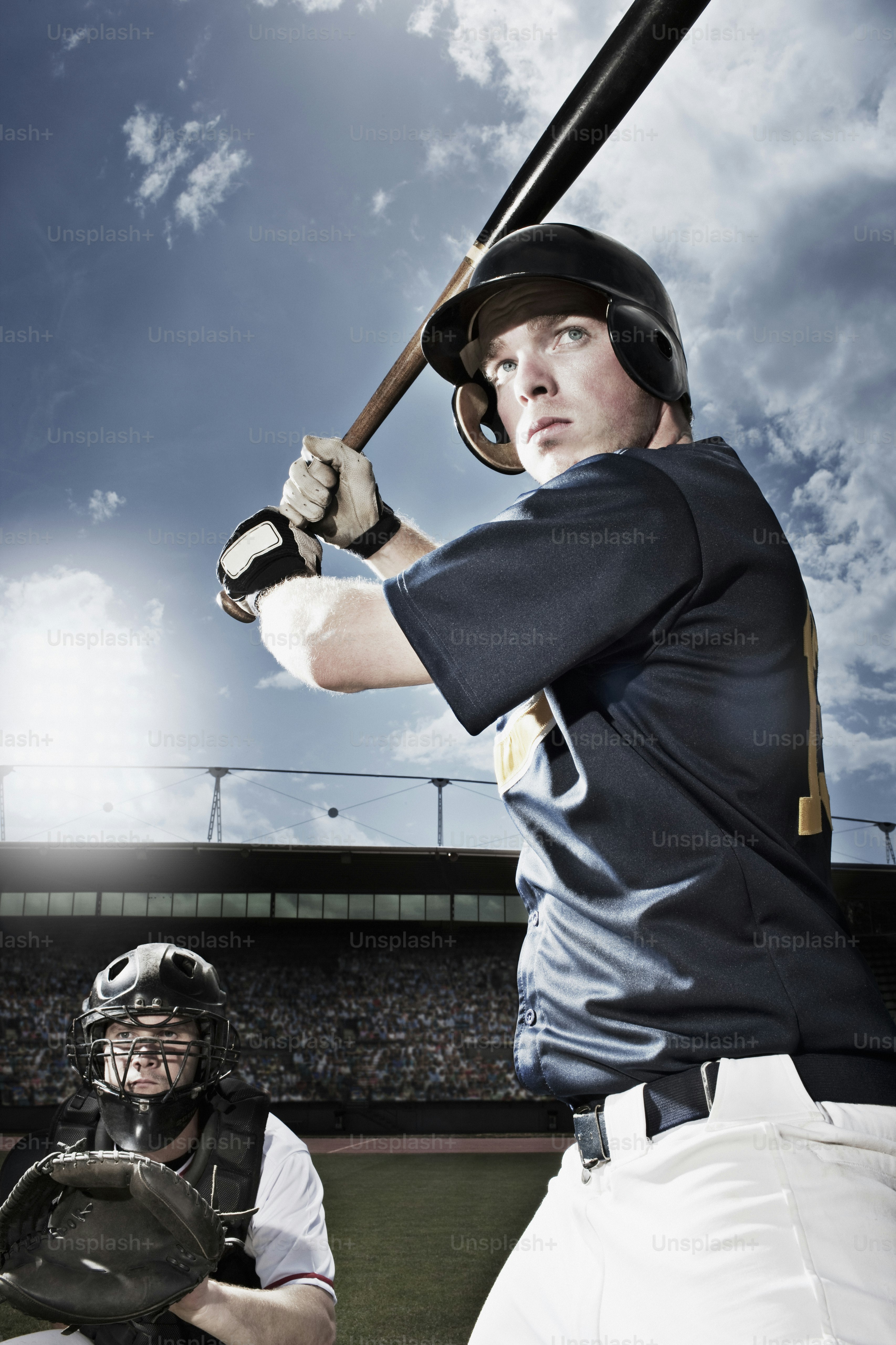 a man holding a baseball bat on top of a field