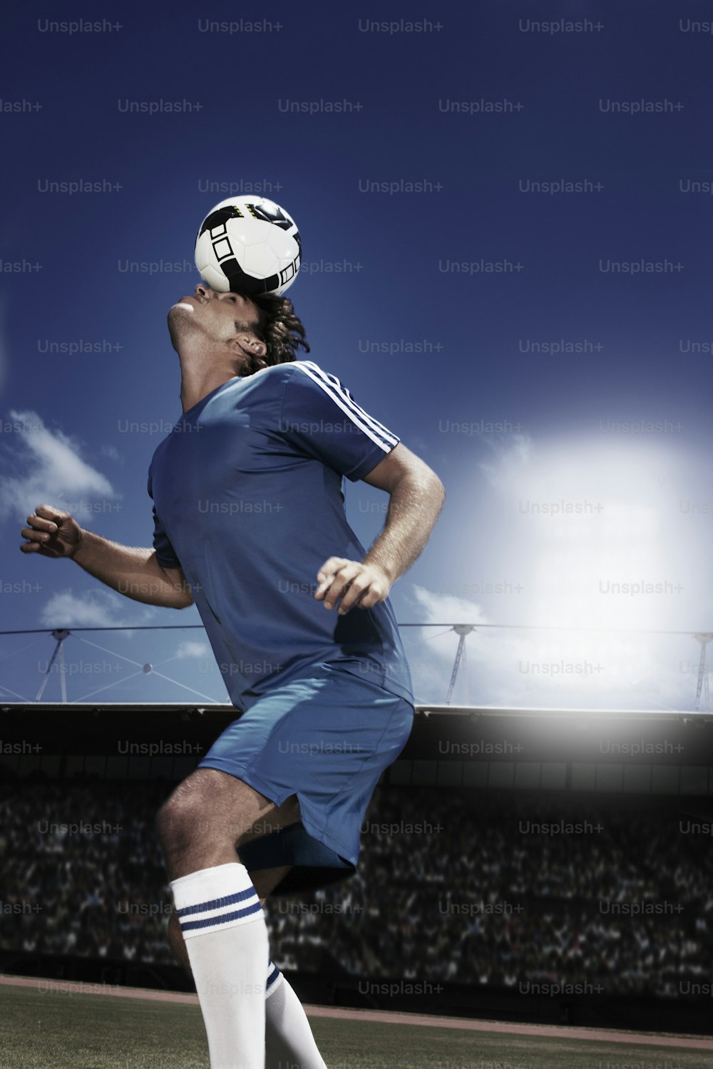 サッカーのユニフォームを着た男がサッカーボールを蹴る