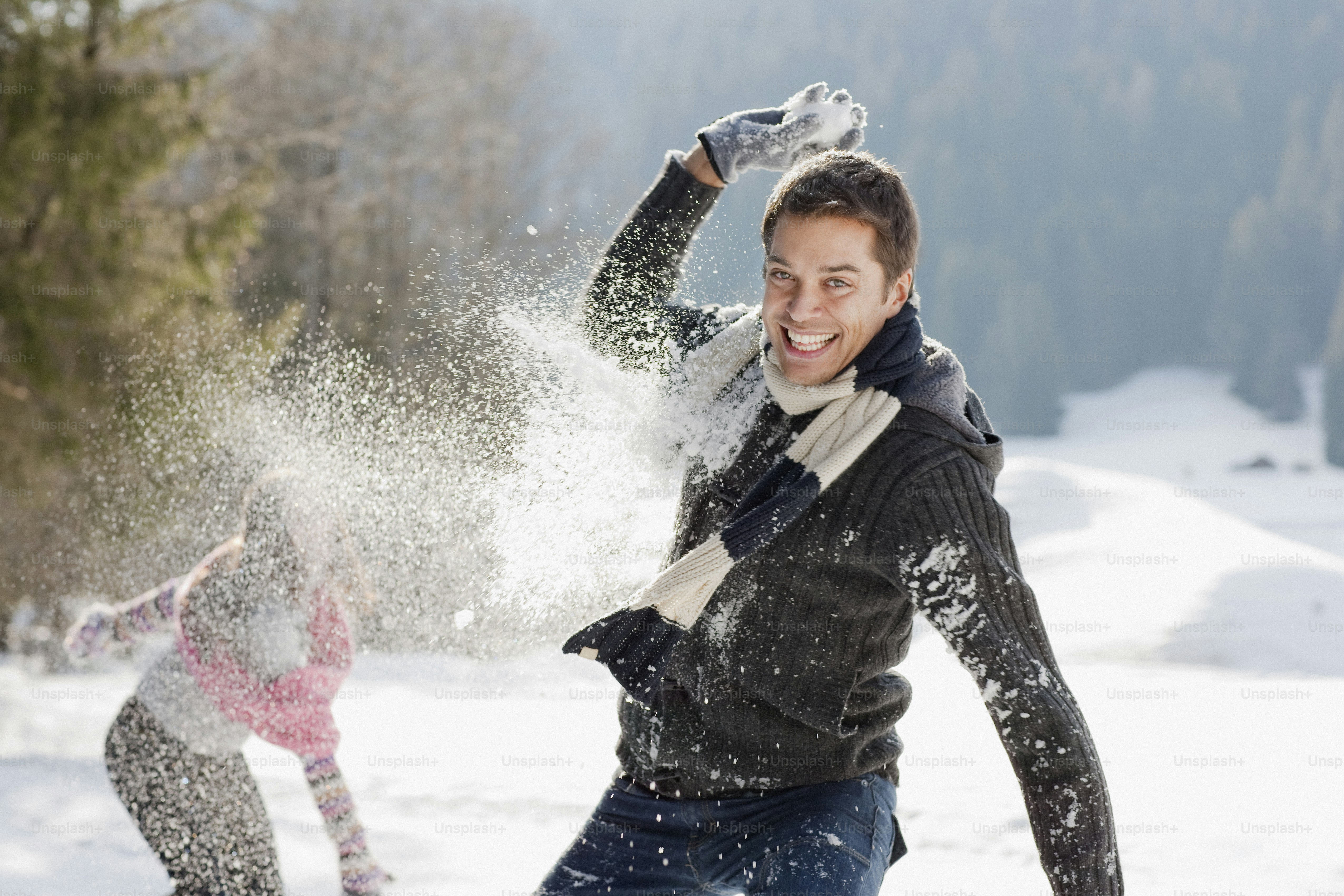 a man and a woman playing in the snow