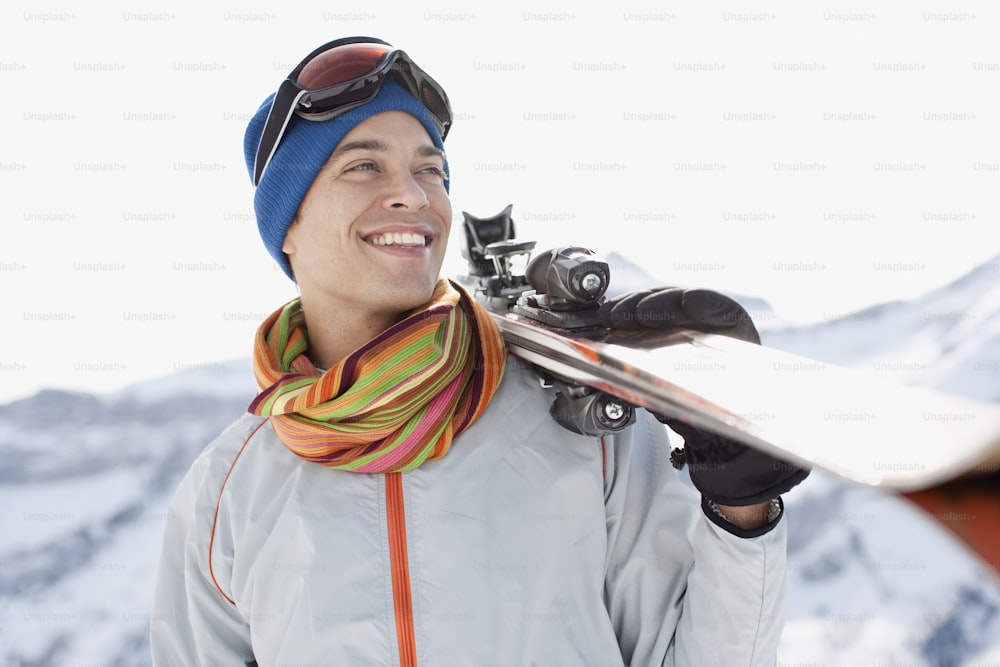 um homem segurando uma prancha de snowboard em suas mãos