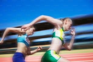 two women running in a race on a track