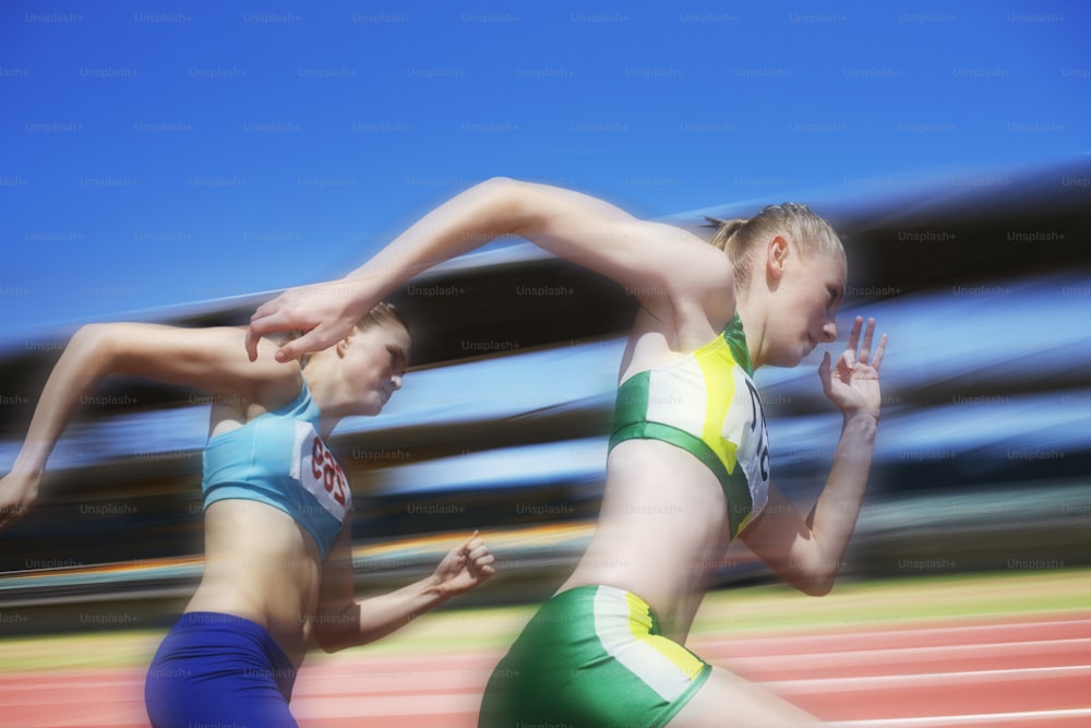 two women running in a race on a track