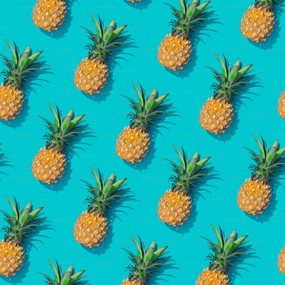 Ananas creativo modello tropicale sfondo blu vivido. Sfondo astratto di arte estiva. Concetto di stampa minimale. Cibo a posa piatta.
