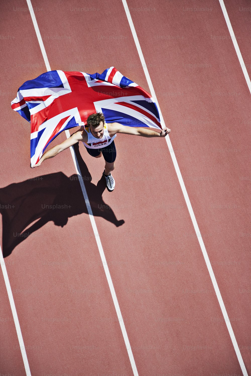 a man holding a british flag on top of a track