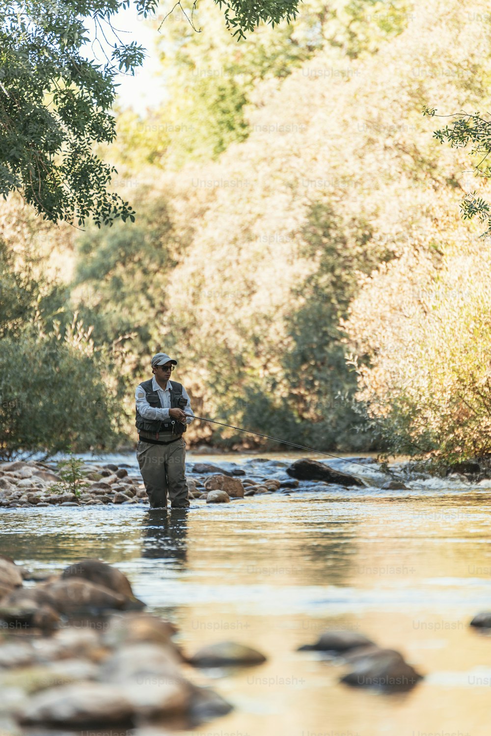 Pescador con mosca usando caña de pescar con mosca en un río hermoso