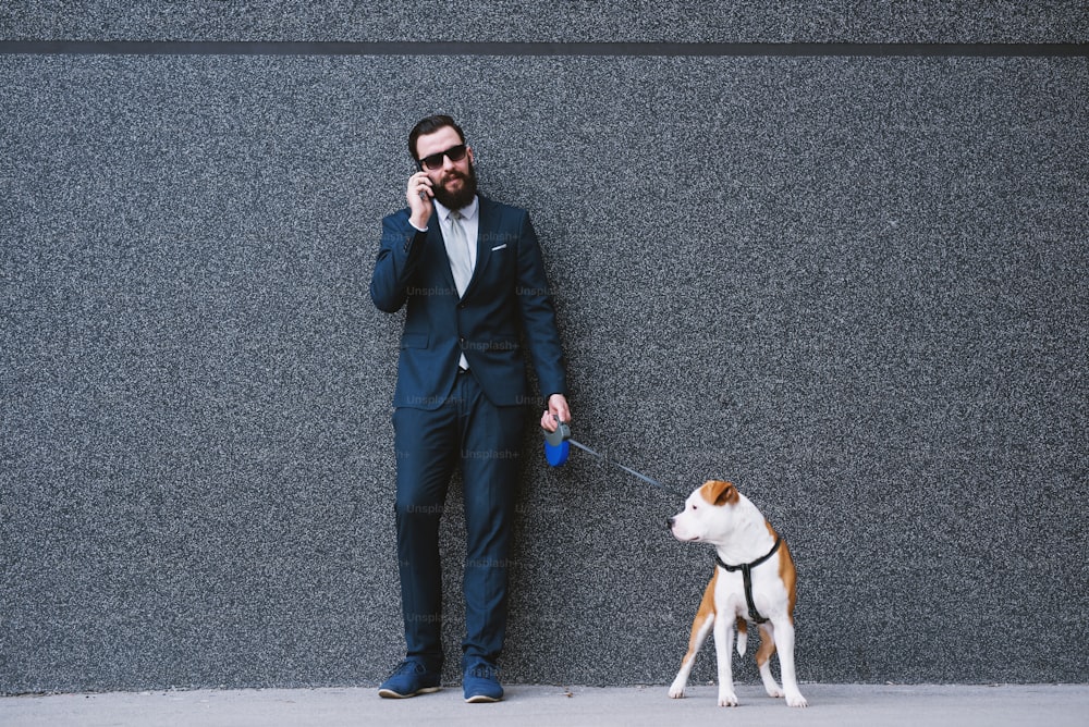 Businessman walking dog at street. Best friends walking. Handsome businessman hipster walking dog.