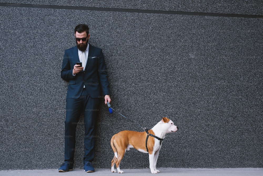 Uomo d'affari che porta a spasso il cane in strada. Migliori amici che camminano. Bel cane da passeggio hipster uomo d'affari.