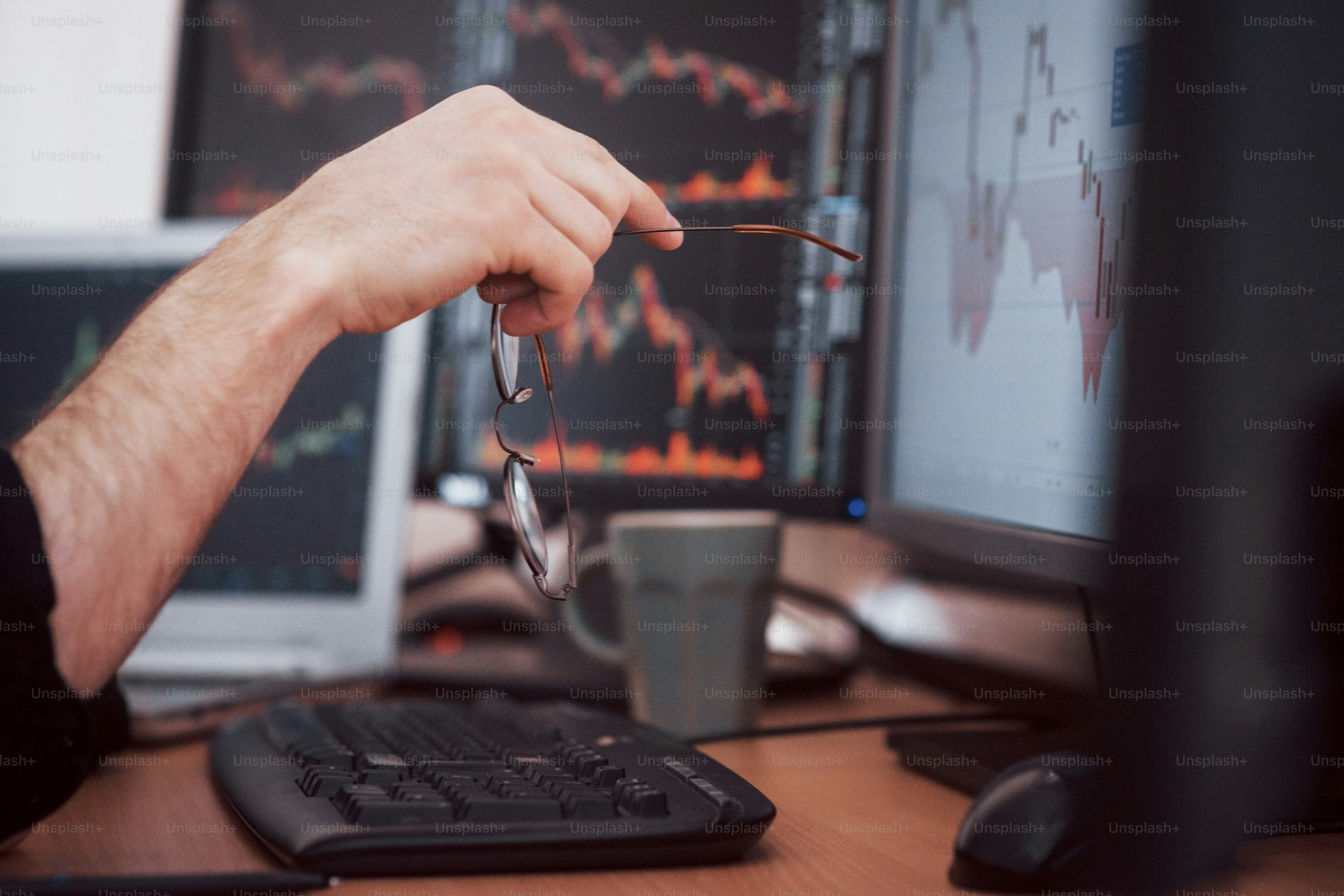 Analyzing data. Close-up of young businessman pointing on the data presented in the chart with pen while working in creative office.
