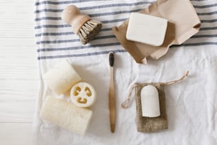zero waste concept. natural plastic free luffa, bamboo toothbrush, brush, coconut soap and crystal deodorant, for hygiene cleaning on towel, eco bathroom essentials. sustainable lifestyle