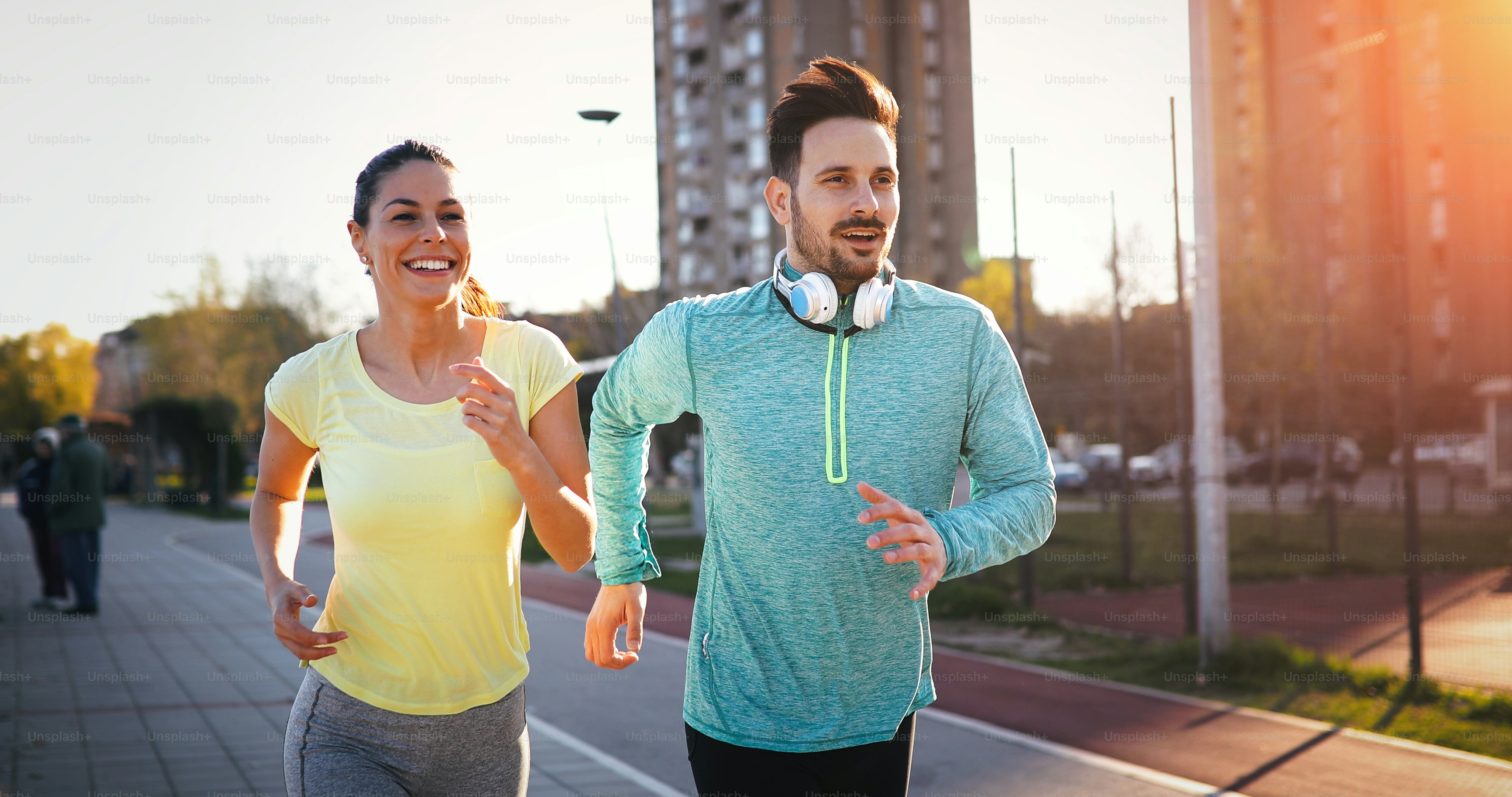 Young fitness couple running together in urban area