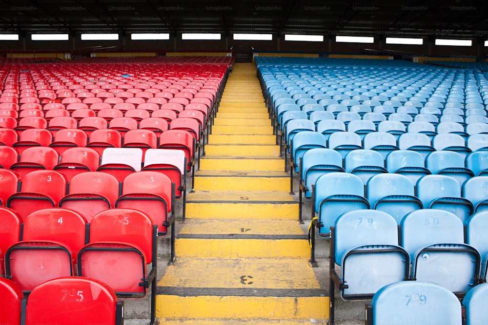 Filas de asientos azules y rojos en un estadio