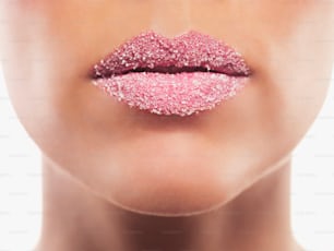 Los labios de una mujer cubiertos de brillo rosa
