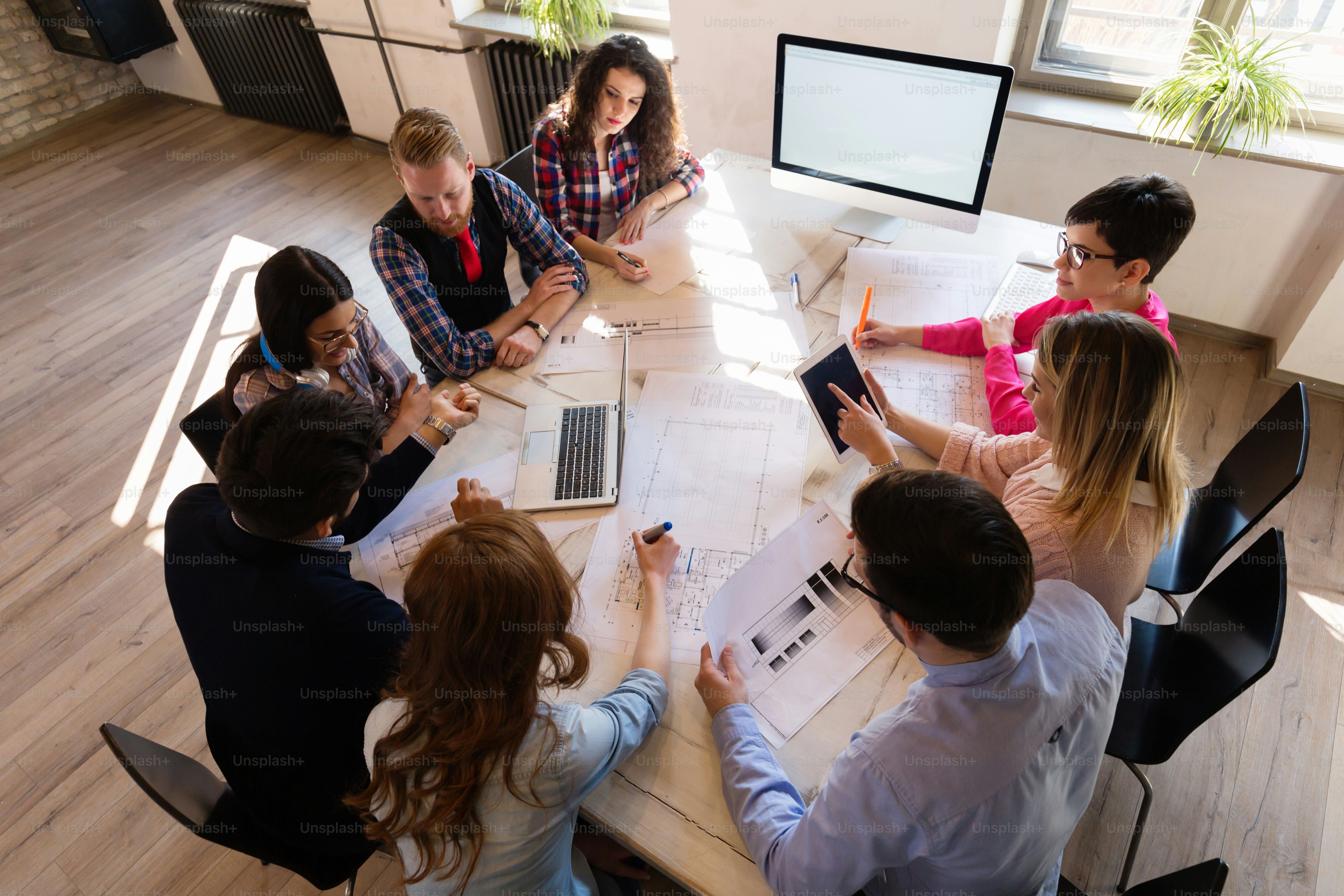 Picture of young attractive architects discussing in office