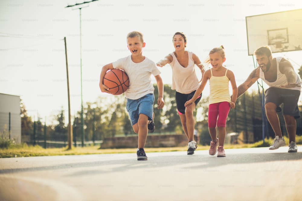 Spring is great for family sport.  Happy family playing basketball outside. On the move.