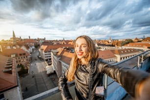 Junge und glückliche Touristin macht Selfie-Foto auf dem Hintergrund des Stadtbildes in Nürnberg, Deutschland