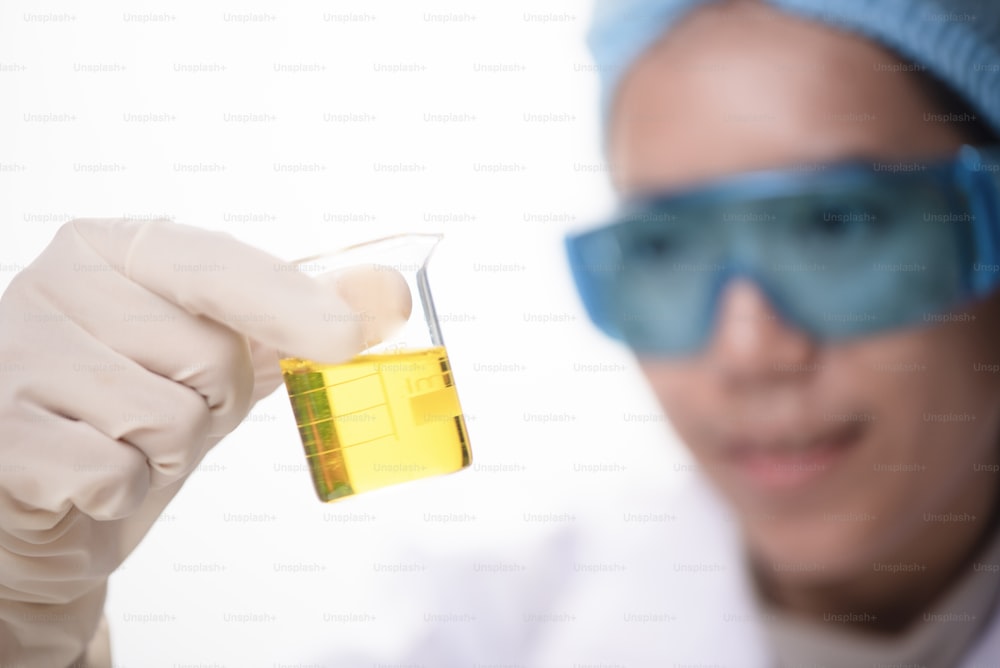 Matraz cónico en la mano del científico con fondo de cristalería de laboratorio, concepto de investigación de laboratorio