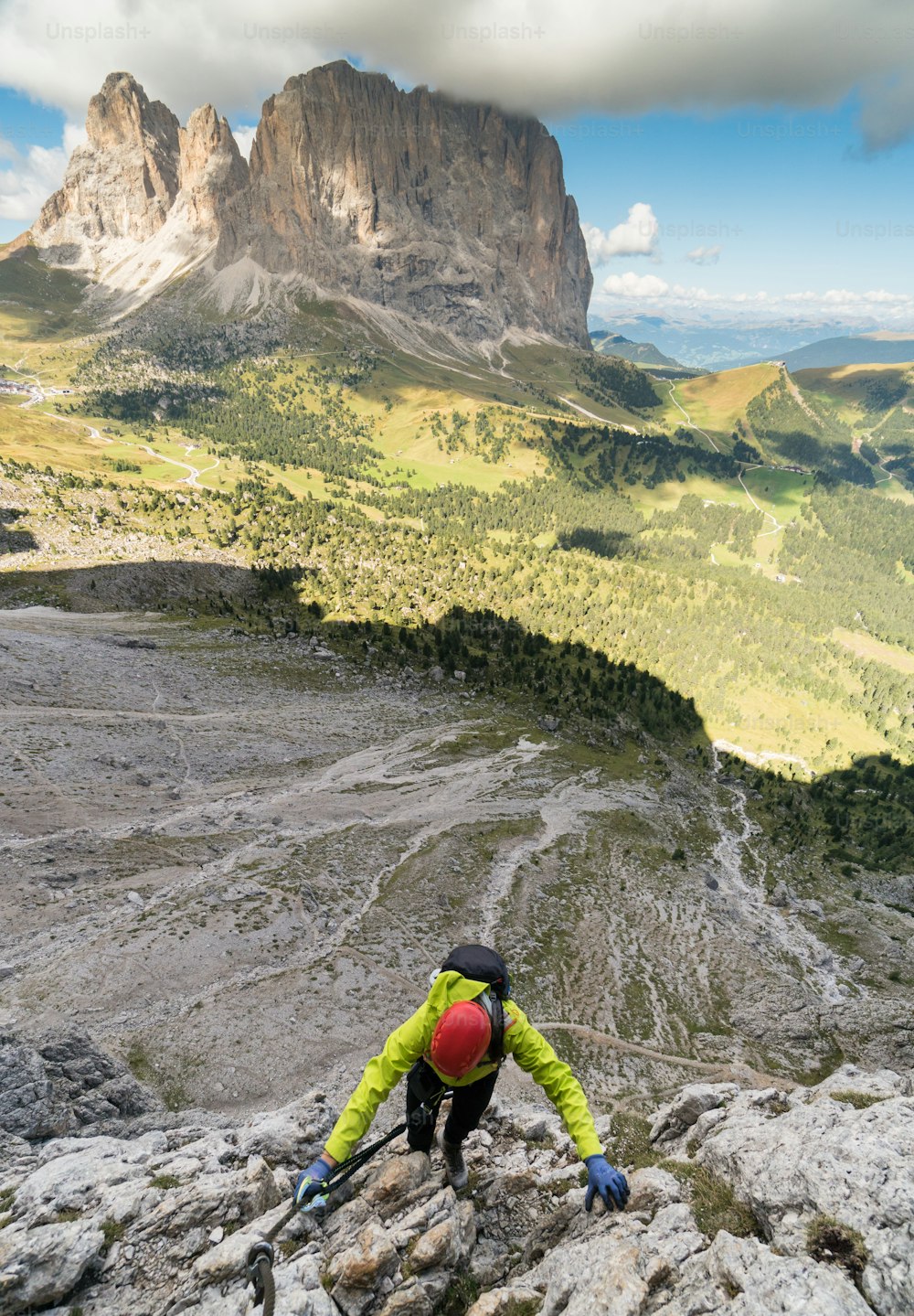 young attractive female mountain climber in the Dolomites of Italy with a great  view of the Langkofel and Passo Sella
