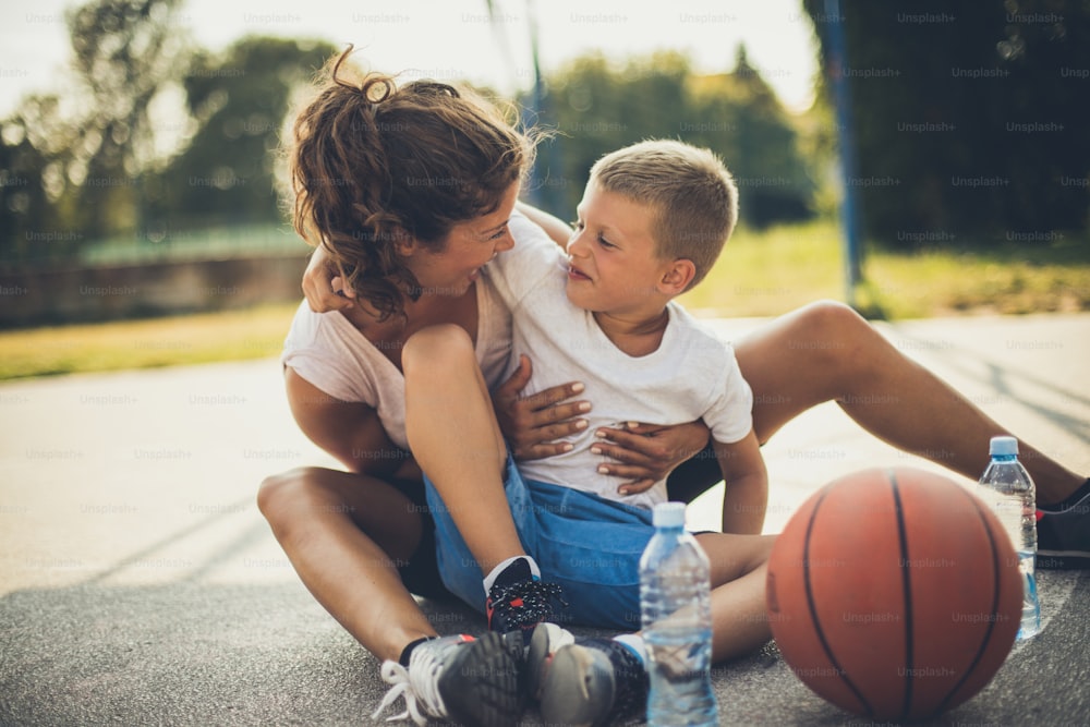 You are my little basketball player. Mother and son on playground.