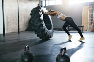 Weight Lifting. Sportswoman Training With Wheel At Gym. Female Athlete Using Wheel For Physical Workout. High Resolution