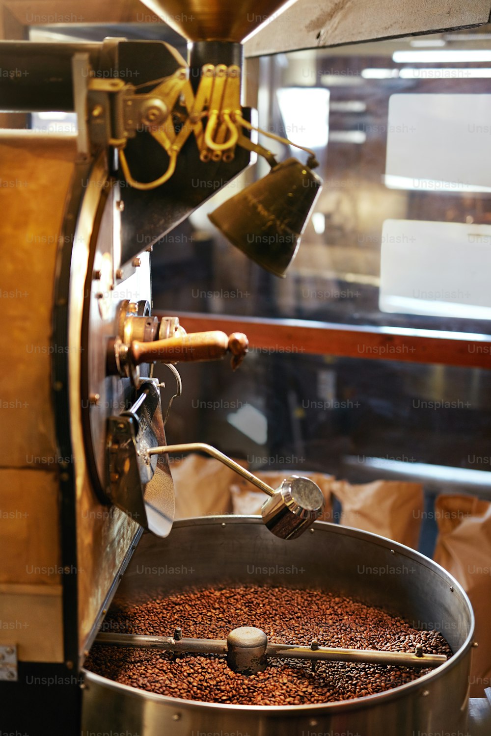 커피숍에서 커피 원두 로스팅. 커피 원두가 있는 커피 프라이 기계. 고해상도