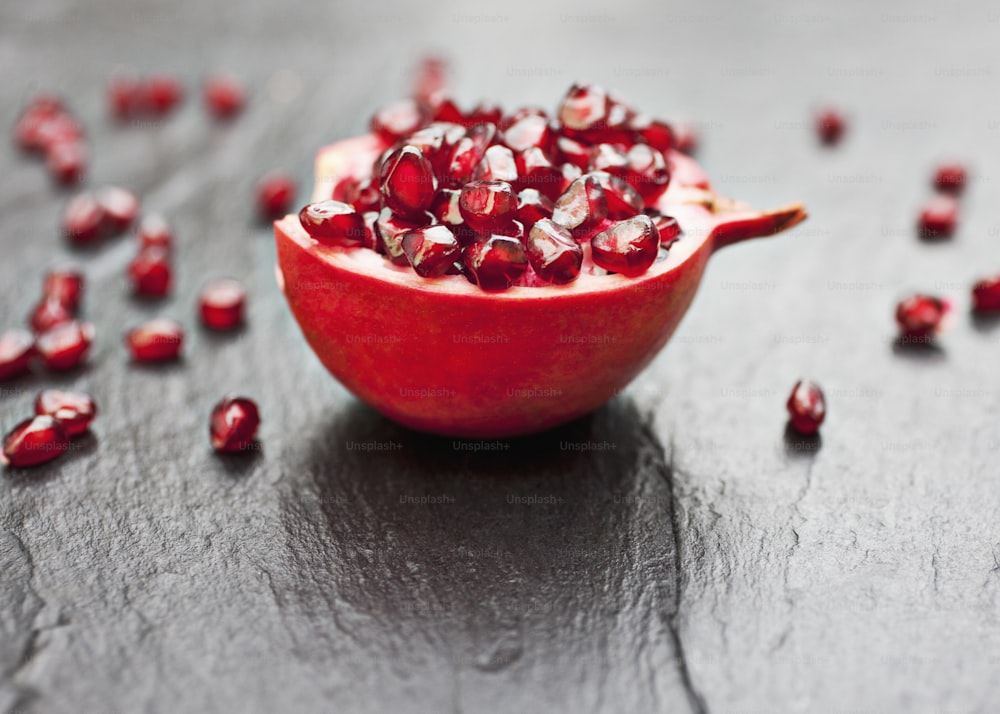 a pomegranate is sitting on a black surface