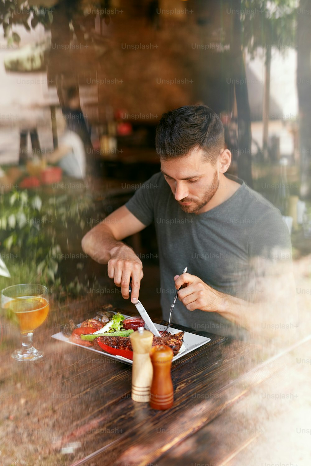 Restaurant. Man Eating Food With Beer At Cafe. Male Eats Barbecue Steak With Grill Vegetables. High Resolution