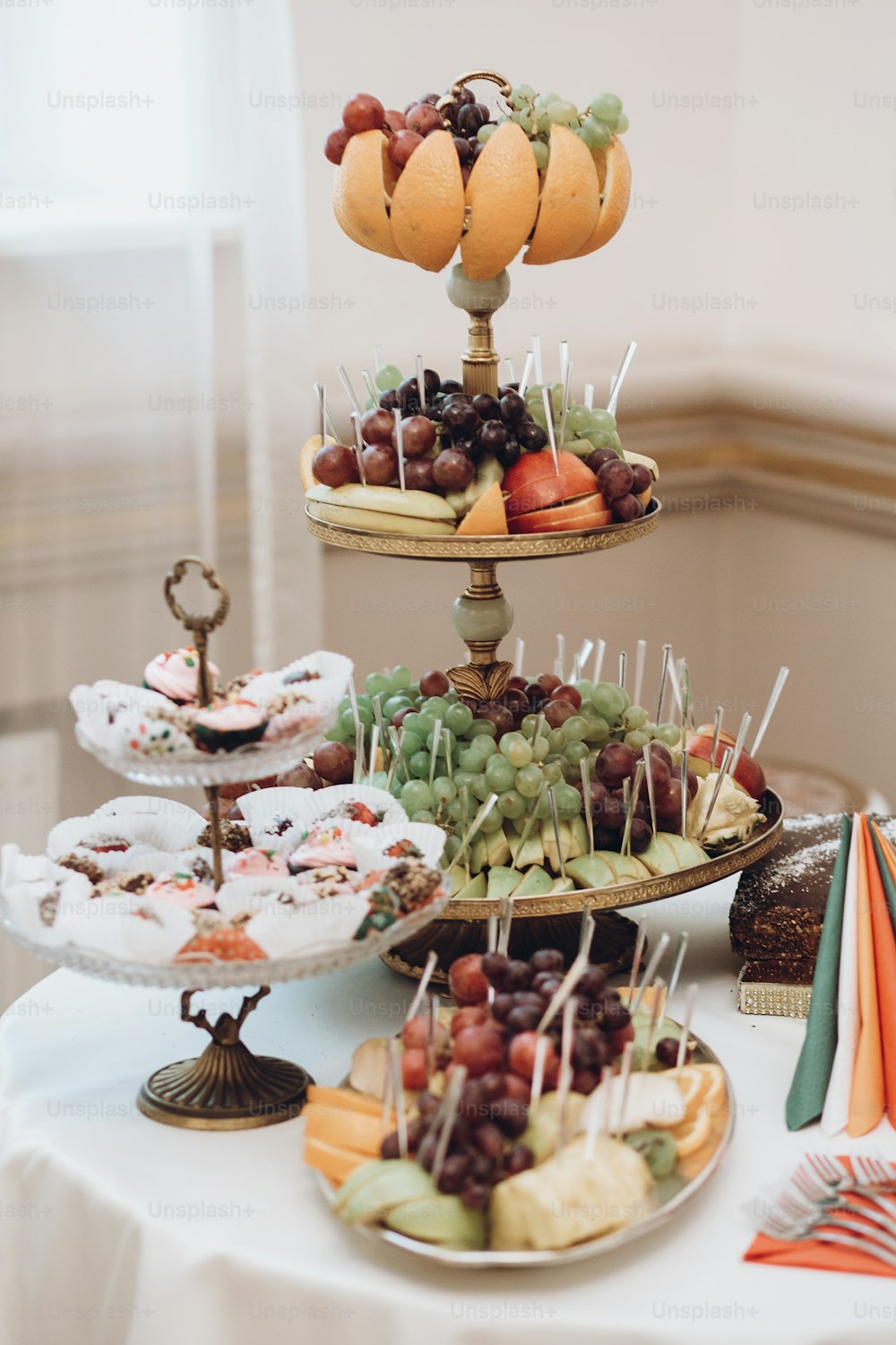 delicious fruits on stand and desserts sweet on table at wedding reception in restaurant. luxury catering. christmas feast. wedding candy bar