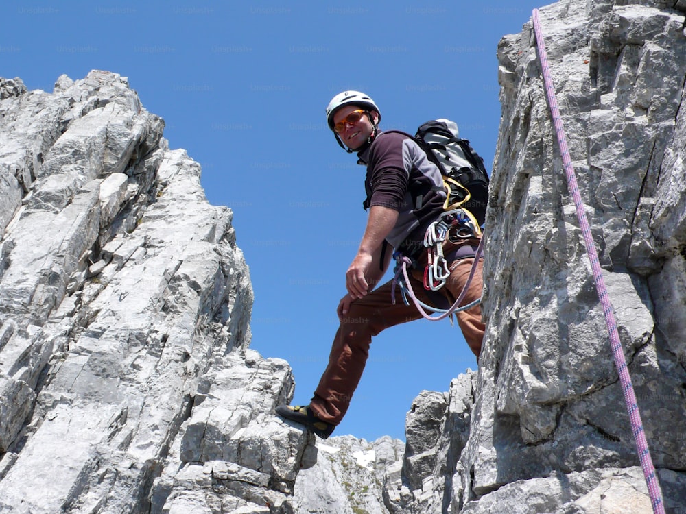 mountain guide rock climbing in the Alps of Switzerland in the Raetikon region near Klosters on a beautiful summer day