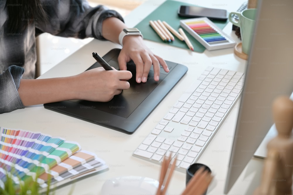 Creative designer using digital drawing tablet in studio workplace