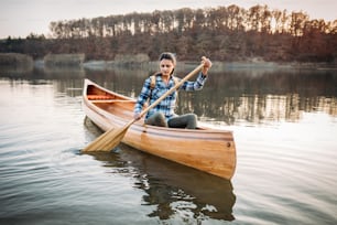 La ragazza di viaggio si diverte a fare canoa sul lago.