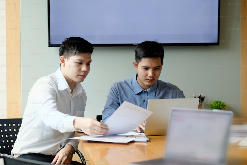 Two colleagues businessman working with computer and finance paper document.
