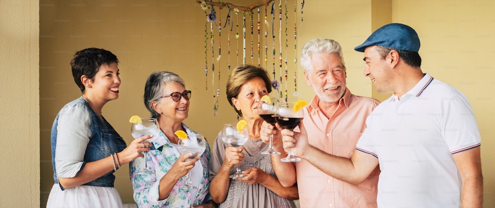 Group of aged adults senior friends drink and enjoy together the leisure celebrate time. Cheerful happy people  with cocktails glass have fun in friendship