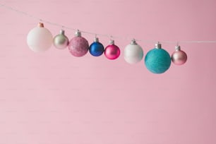 Colorful pastel Chrstmas decoration balls on pink background.