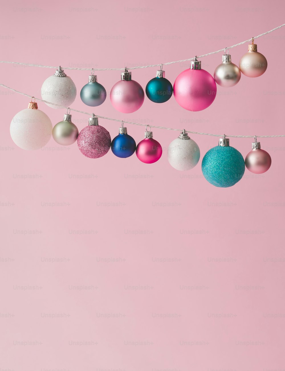 Colorful pastel Chrstmas decoration balls on pink background.